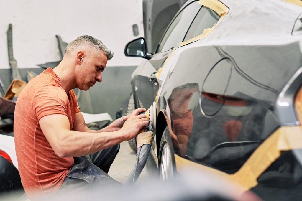 a mechanic polishing an sport car