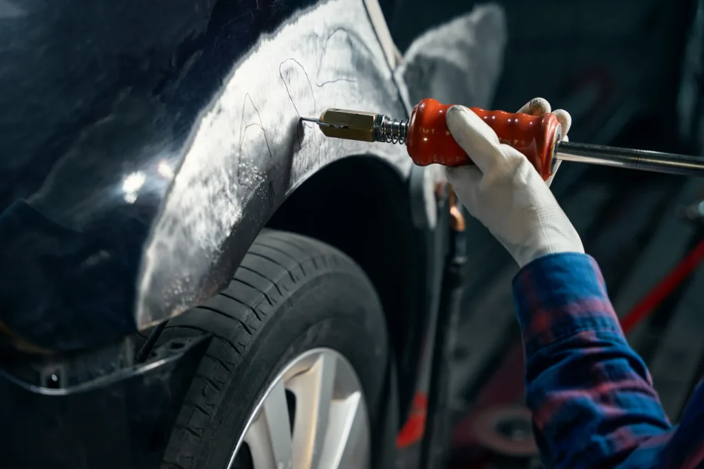 mechanic working with front fender in tire fitting